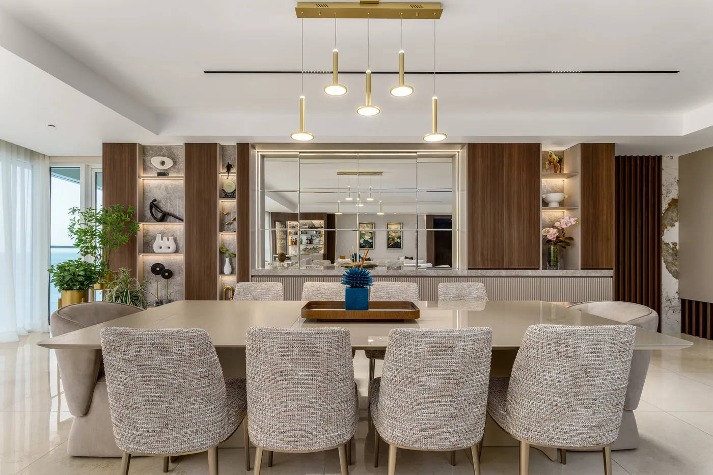 Comedor con mueble de pared en madera y repisas iluminadas