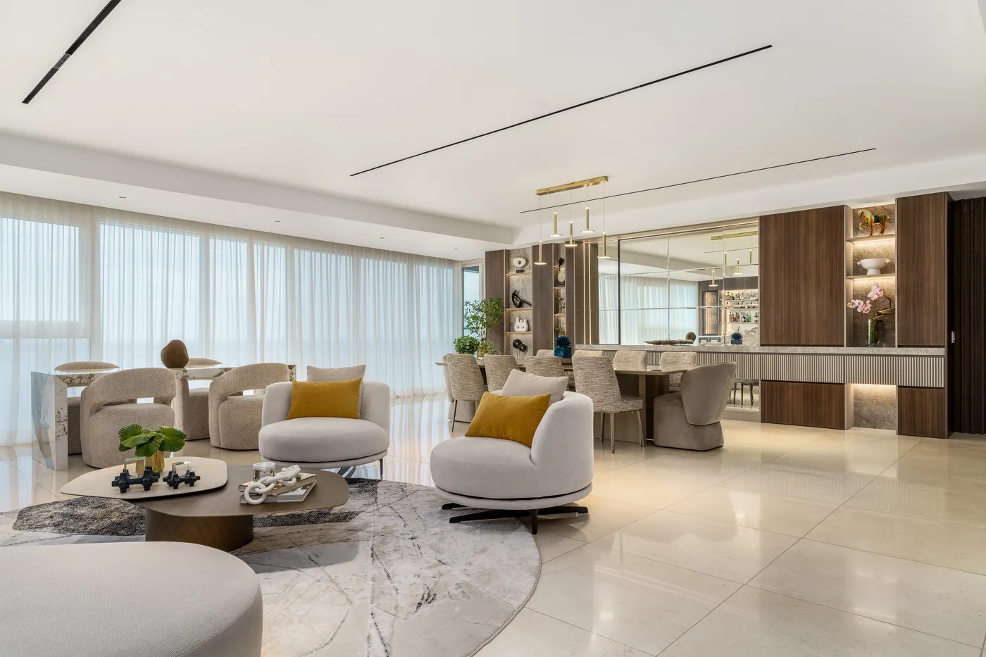 Sala y comedor amplios con mueble de madera iluminado y sillones tapizados